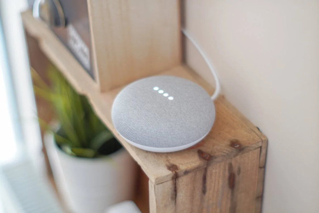 An image of a voice-activated device on a brown shelf